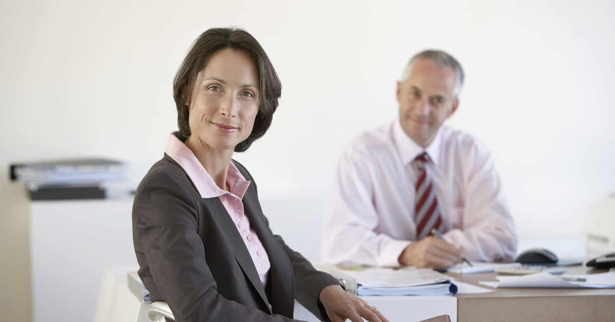 Portrait of businesswoman with male colleague in office