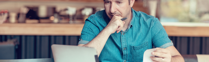 Restaurant owner consulting with AI Chat gpt on a tablet while looking at bills and expenses of his small business.