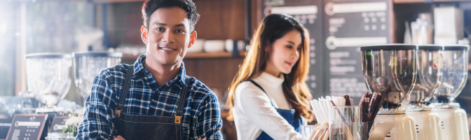 Male and female working at coffee shop.