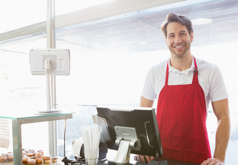 Casual server posing behind the counter at the bakery