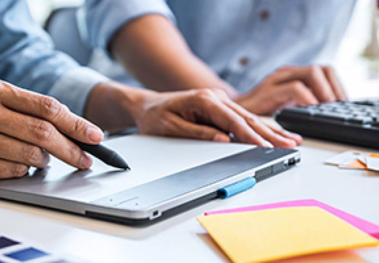 A closeup to a desk where business associates are looking over branding documents.