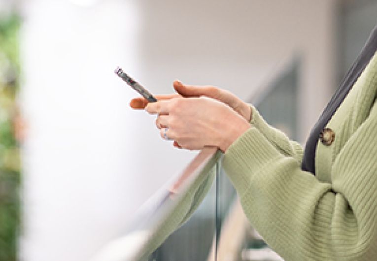 A person viewing a mobile phone in their hands.