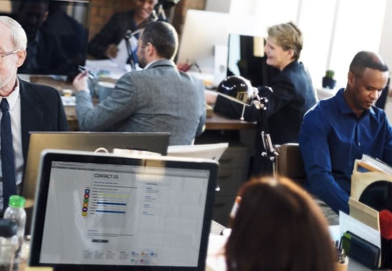 Office workers using technology at their desks