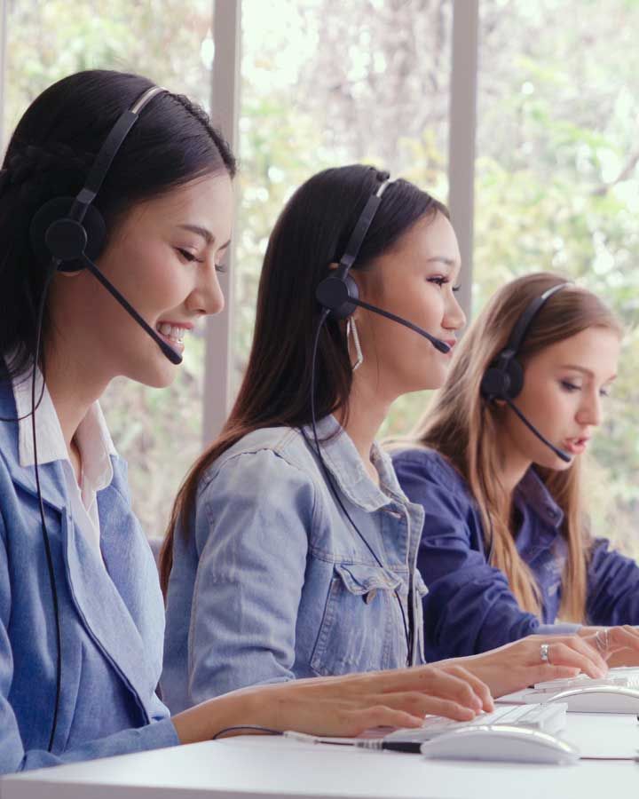 Three women wearing phone headsets